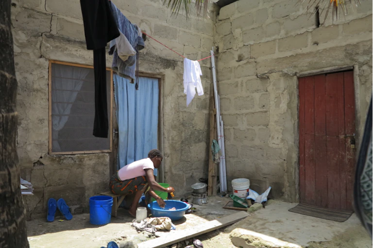 Person doing washing next to a structure.