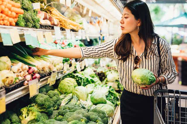 woman choosing fresh veg in supermarket