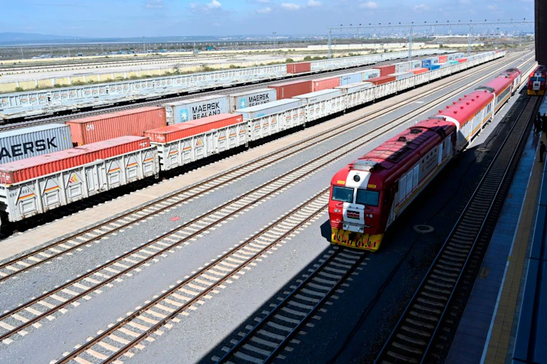 Trains and cargo at a station.
