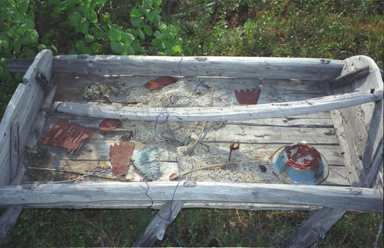 various small objects are strewn on the roof of a sled lying in a field