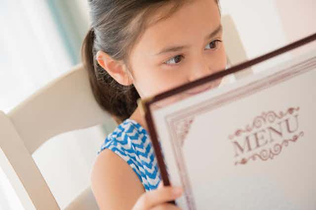 A child reading a menu.