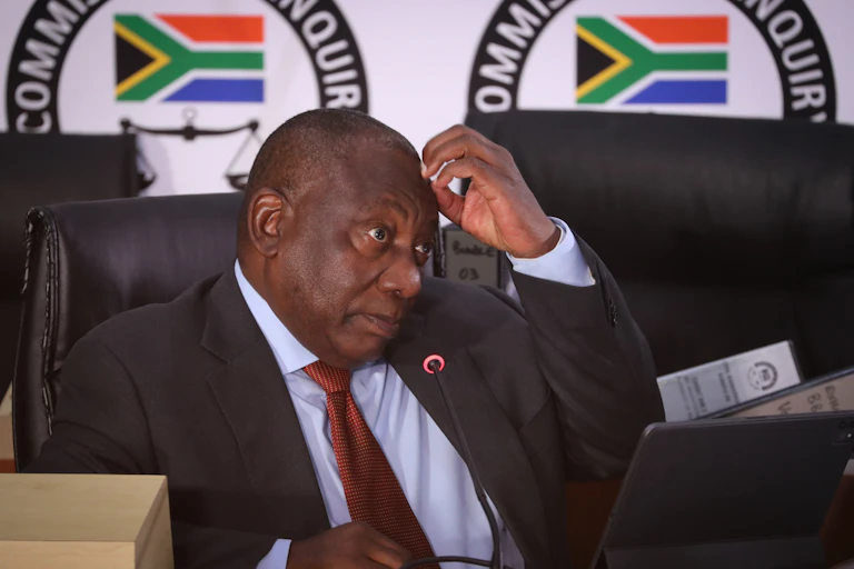 Man sitting on a chair with his hand to his head.