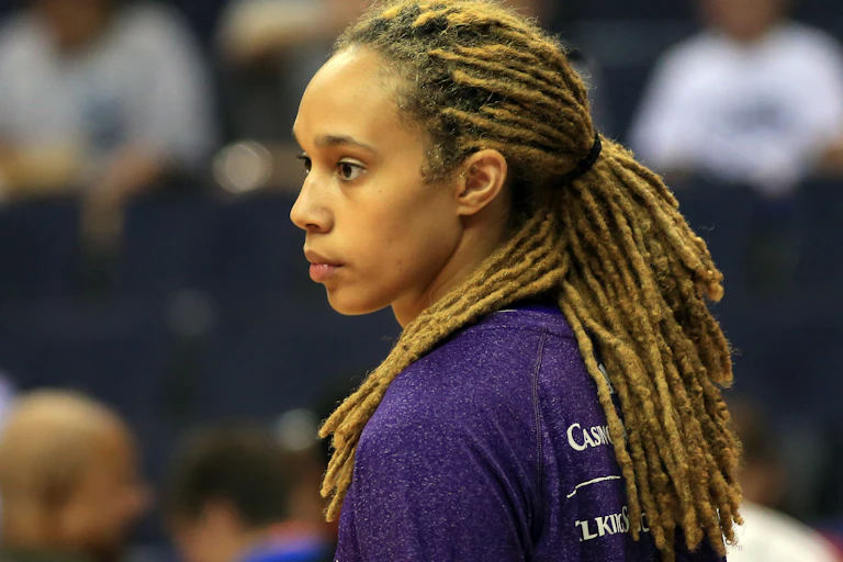 A black woman is seen with golden brown dred locks.