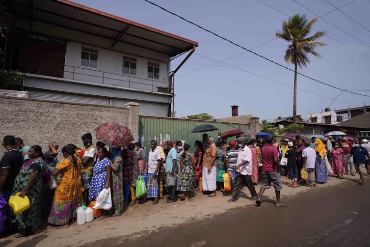 Sri Lankans queue to buy kerosene oil for cooking.