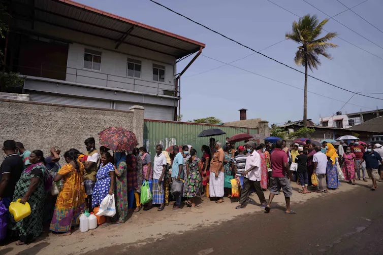 Sri Lankans queue to buy kerosene oil for cooking.