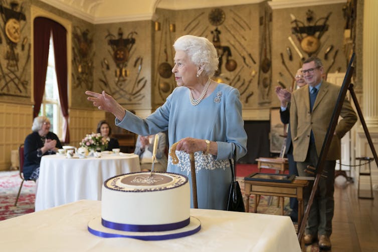 Queen Elizabeth II cutting a cake for her Platinum Jubilee at Sandringham House in 2022.