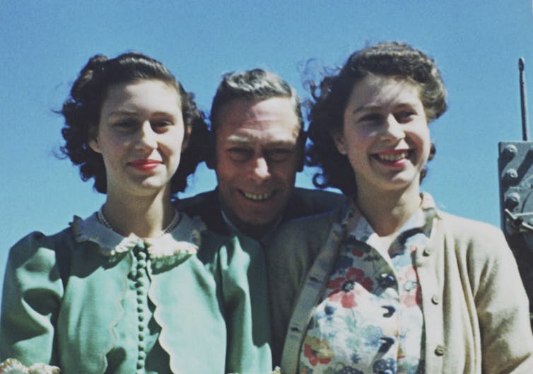 Princesses Margaret and Elizabeth with their father, King George VI, on a boat in 1947.