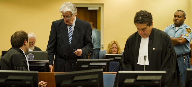 Bosnian Serb leader Radovan Karadzic with lawyers at the Yugoslavia war crimes tribunal at the Hague, October 2012.