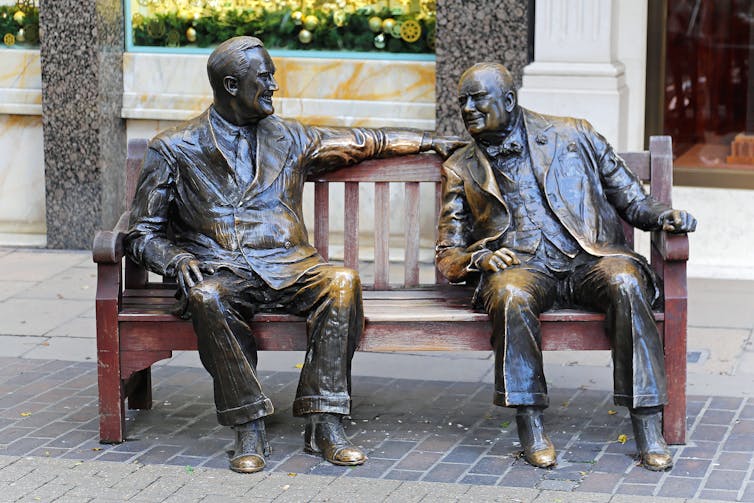 bronze sculptures of Franklin D Roosevelt and Winston Churchill on a wooden bench.