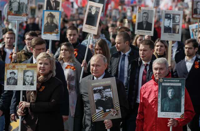Russian president, Vladimir Putin, and Russian people carry portraits of their relatives, participants of World War II during an Immortal Regiment memorial demonstration in Moscow.