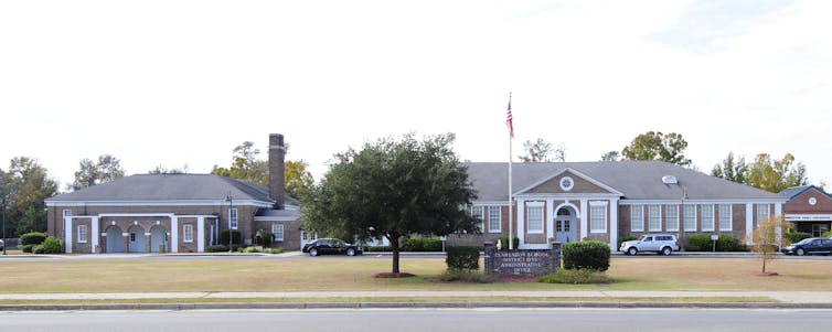 A one-story brick building with a flagpole out front.