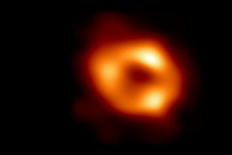 An image showing a donut-shaped cloud of reddish-orange gas.