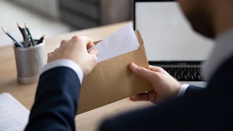 Man opening an envelope at a desk