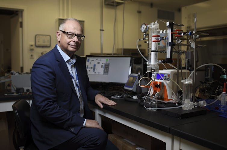 A man sitting at a table with technological equipment on it