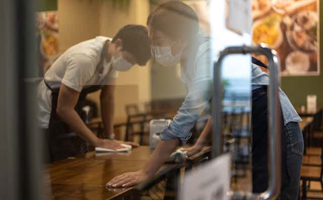 Workers clean tables in a restaurant.