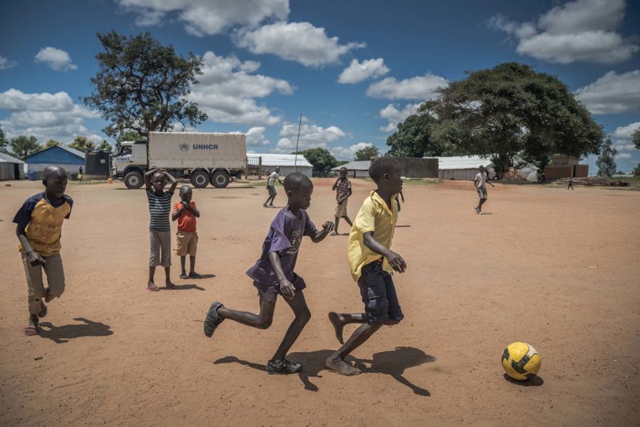 Children playing football in a field