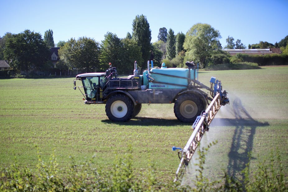 Une machine agricole répandant des pesticides dans un champ