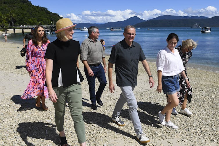 Labor leader Anthony Albanese walks along a beach.