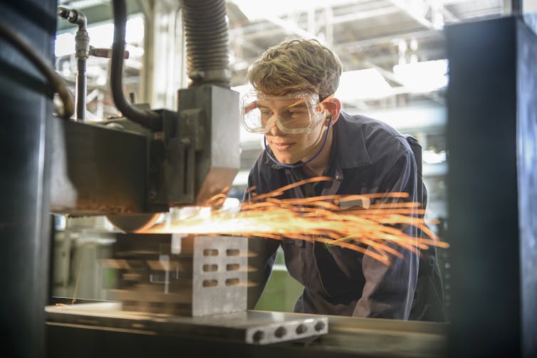 Young man in working in front of machinery