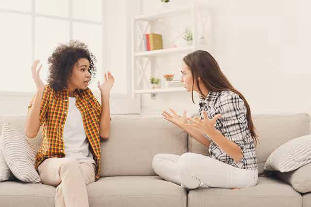 Dua perempuan berdebat saat mereka duduk di sofa