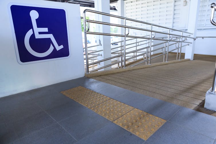 A large wheelchair sign is visible to the left of a wheelchair ramp.