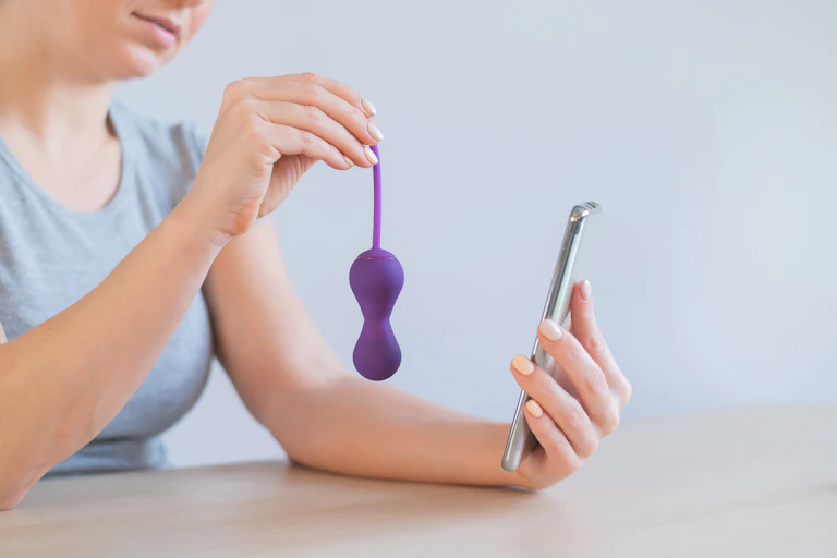 woman holds plastic object and mobile phone