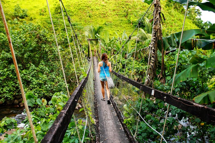 Woman on bridge in rainforest