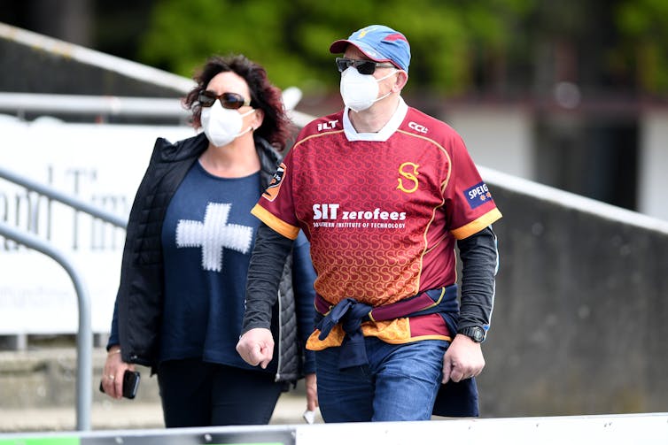 Couple in masks going to football game, New Zealand