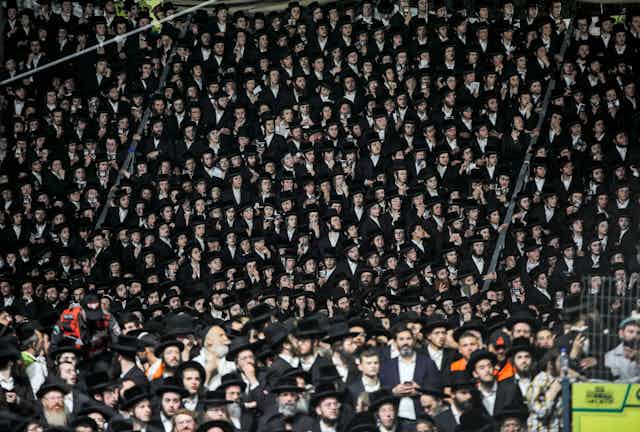 Hundreds of Jewish men gathered for a pilgrimage wearing traditional dress.