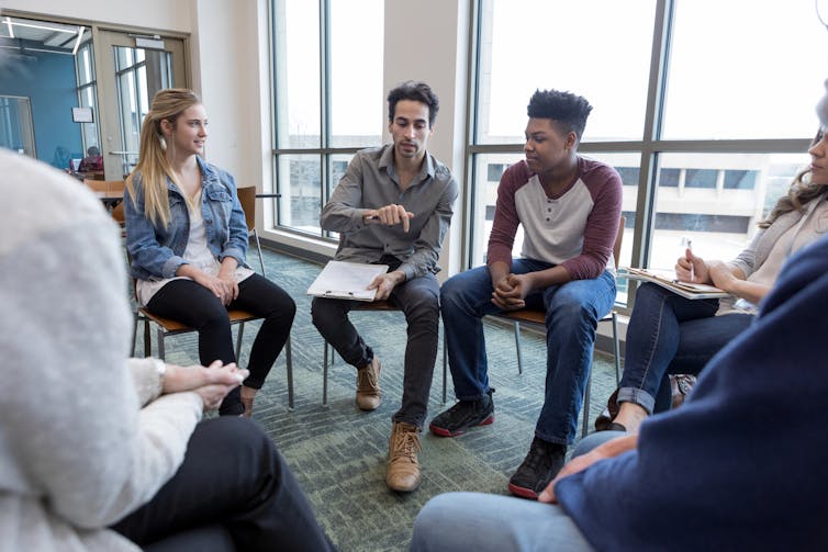 People sitting in a circle in a group therapy session.