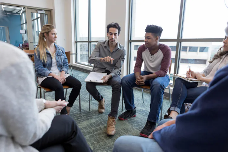 People sitting in a circle in a group therapy session.