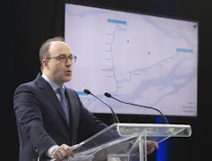 Un homme prend la parole devant un écran