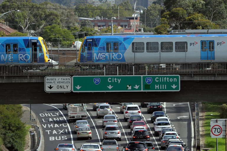 Train on rail bridge over freeway