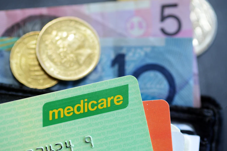Medicare card and money coming out of a wallet.
