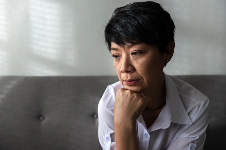 middle aged woman sitting, thinking