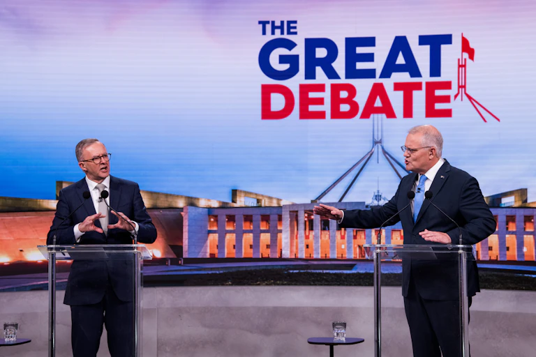 two men gesturing at lecterns