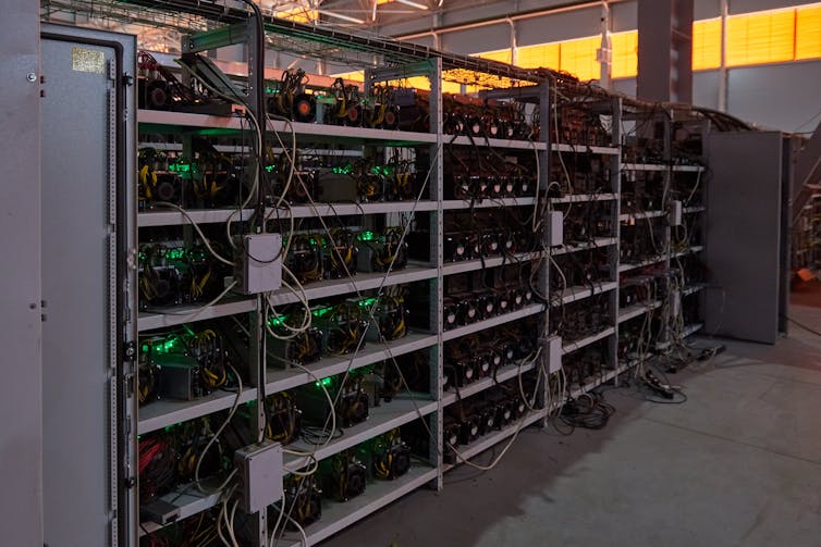 A shelf filled with computer servers and wires.