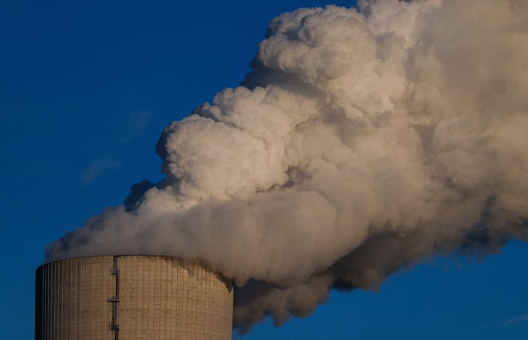 Steam rising from a cooling tower at a coal-fired power plant.