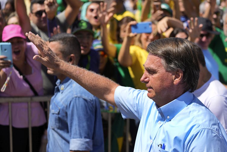 Le président brésilien Jair Bolsonaro, fait un salut avec son bras
