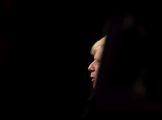 Un perfil de Boris Johnson en medio de un fondo negro.