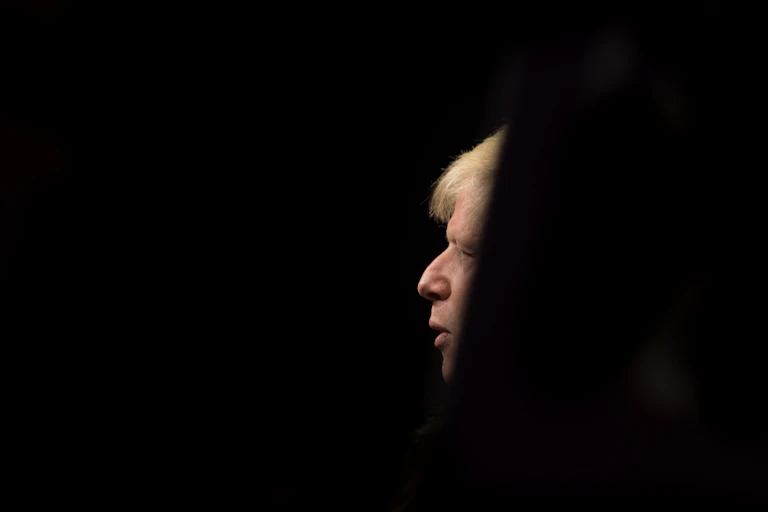 Un perfil de Boris Johnson en medio de un fondo negro.