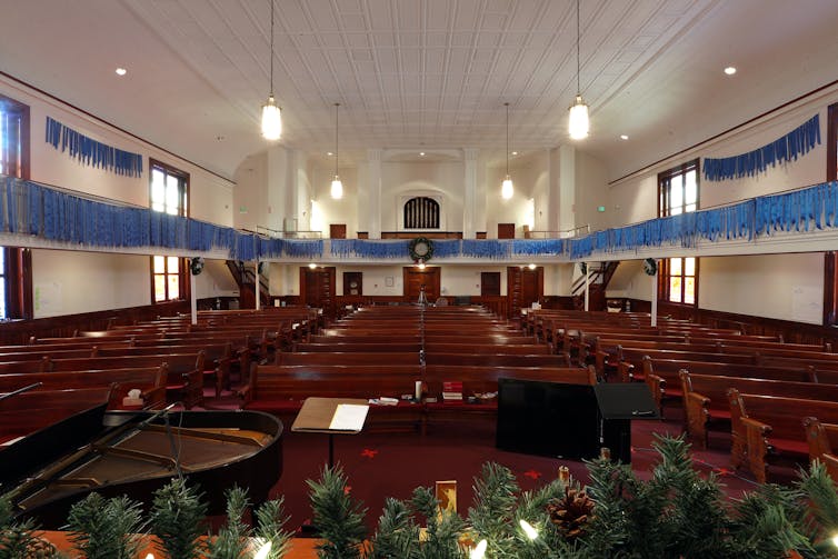 A church interior with blue ribbons hung from walls that each represent one person dead from COVID-19.