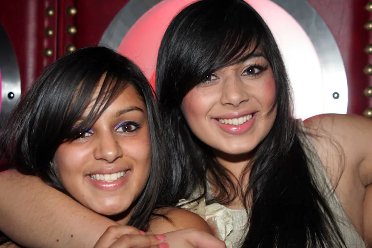 Two teenage girls in a nightclub setting.