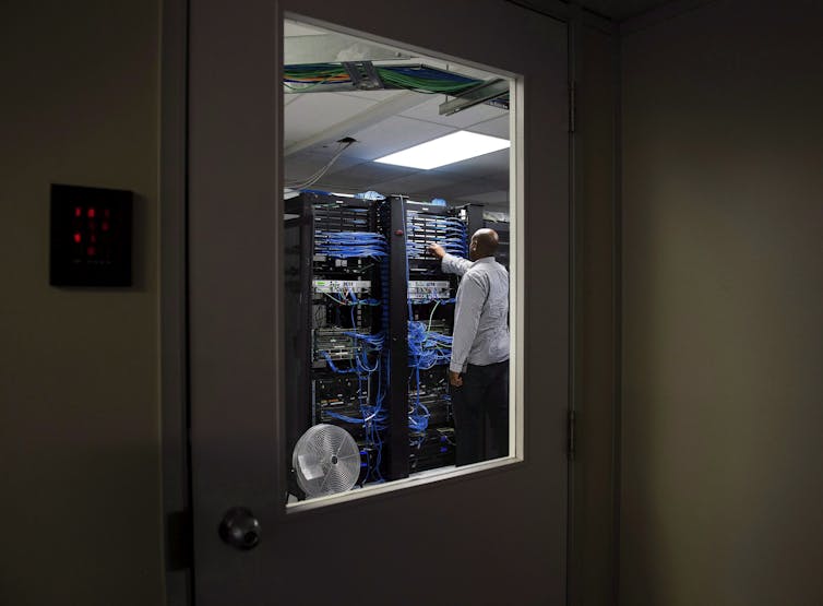 A man adjusting the networking cables on a circuit board.