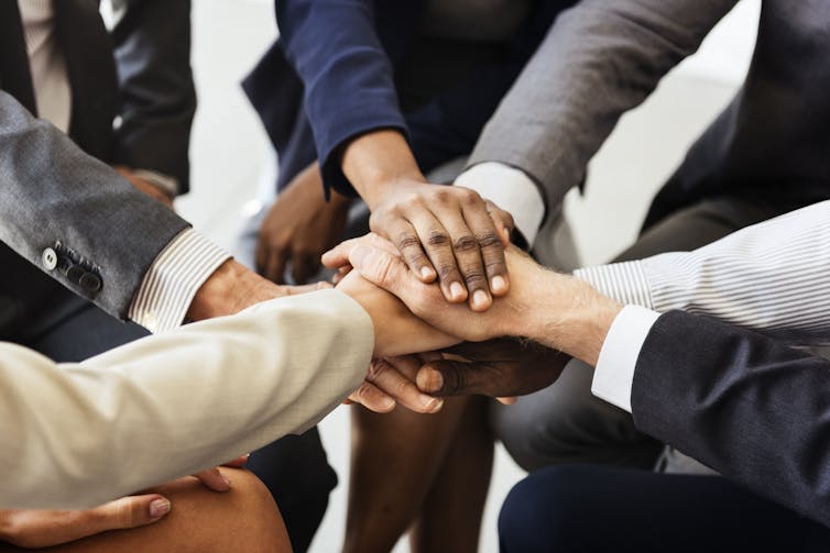 Group of people stacking hands together in a circle