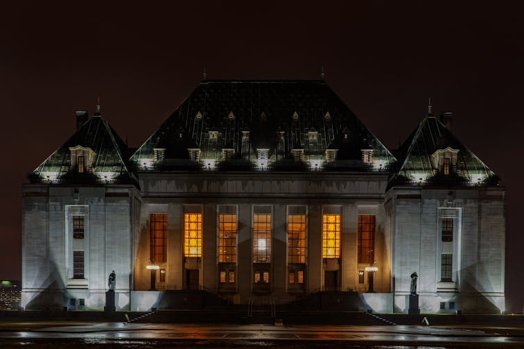 An image of the Supreme Court of Canada building in Ottawa lit up at night