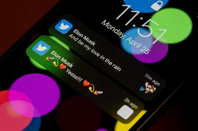 Two of Elon Musk's tweets are visible on the lock screen of a smartphone