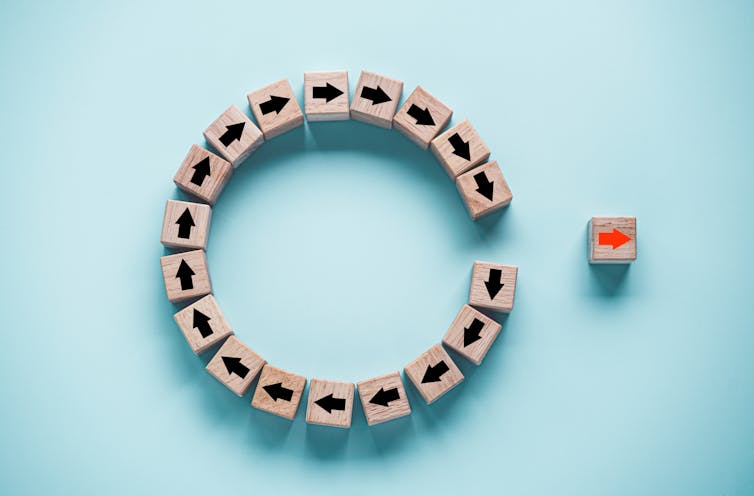 Graphic showing a circle of connected parts, with one part outside pointing in another direction.