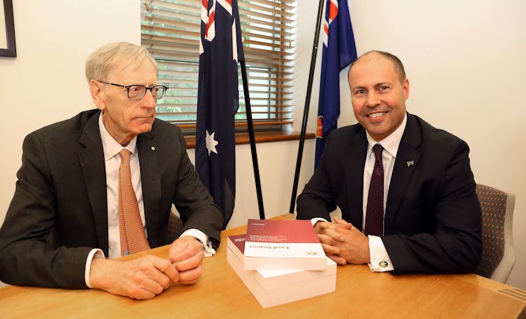 Banking royal commissioner Kenneth Haynes hands his report to Treasurer Josh Frydenberg.