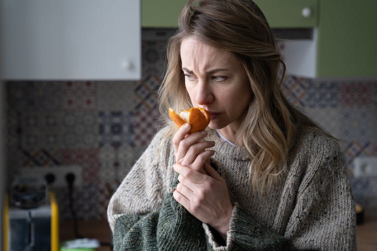 sick woman sniffs orange